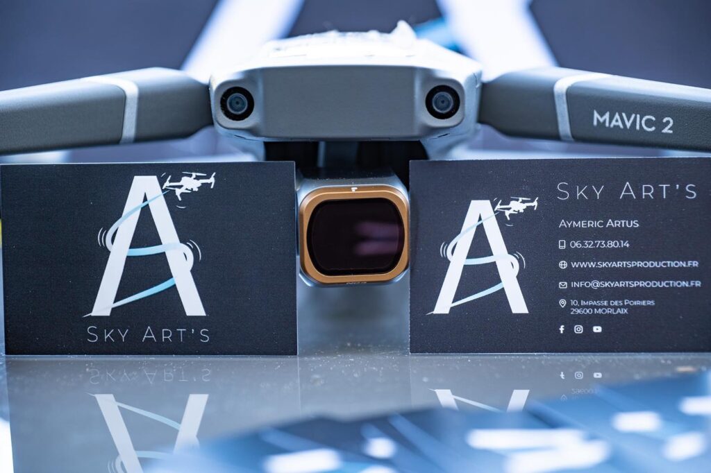 Drone Mavic 2 Pro posé à côté des cartes de visite Sky Art's Production et Aymeric Artus