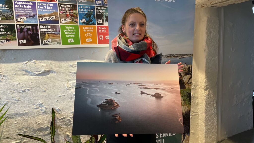 Marie Dünvaël de l’office de tourisme de Plougasnou recevant un tirage photo de la baie de Morlaix