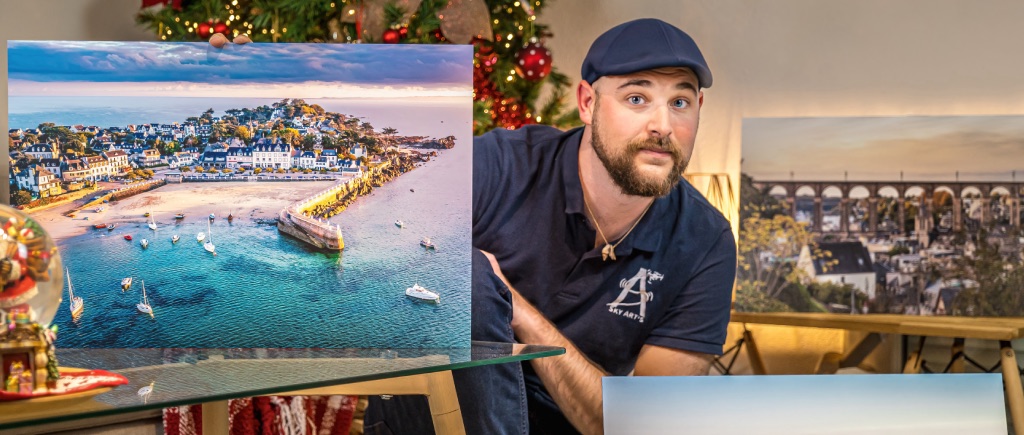 Aymeric Artus tenant un tirage photographique aérien de Locquirec