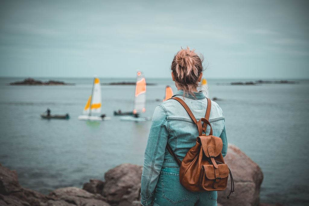 Jeune fille en short en jean sur l’île de Batz, paysage côtier en arrière-plan