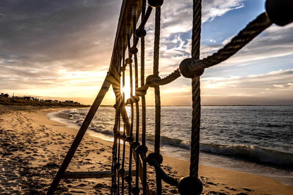 Jeux pour enfants sur la plage de Plouescat au coucher de soleil avec ciel orangé