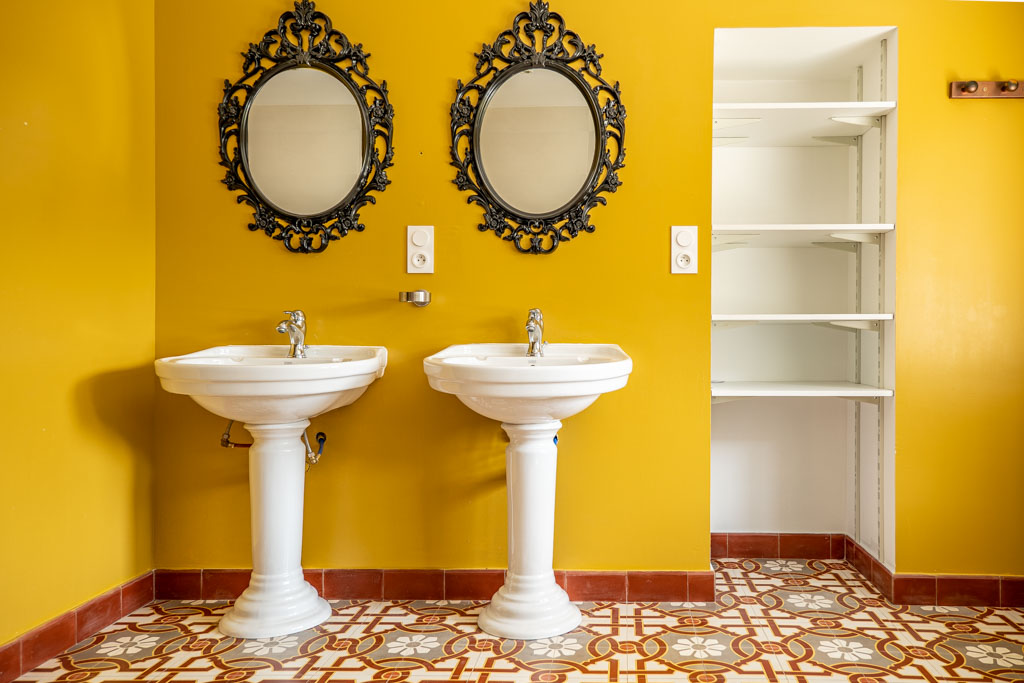 Photo immobilière salle de bain vintage colorée avec double vasque et moulures