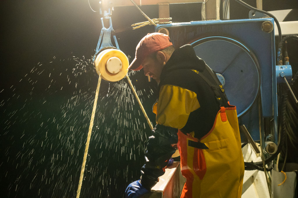 Pêcheur professionnel en action sur son bateau en mer