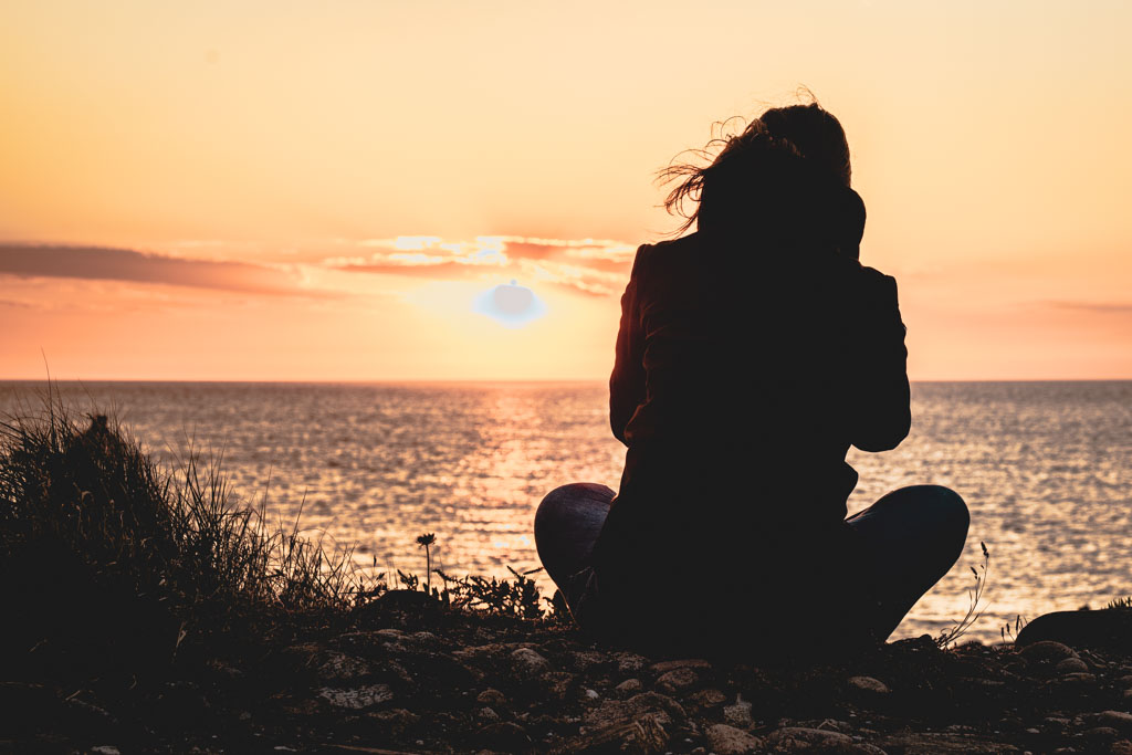 Jolie femme rousse au coucher du soleil avec lumière dorée